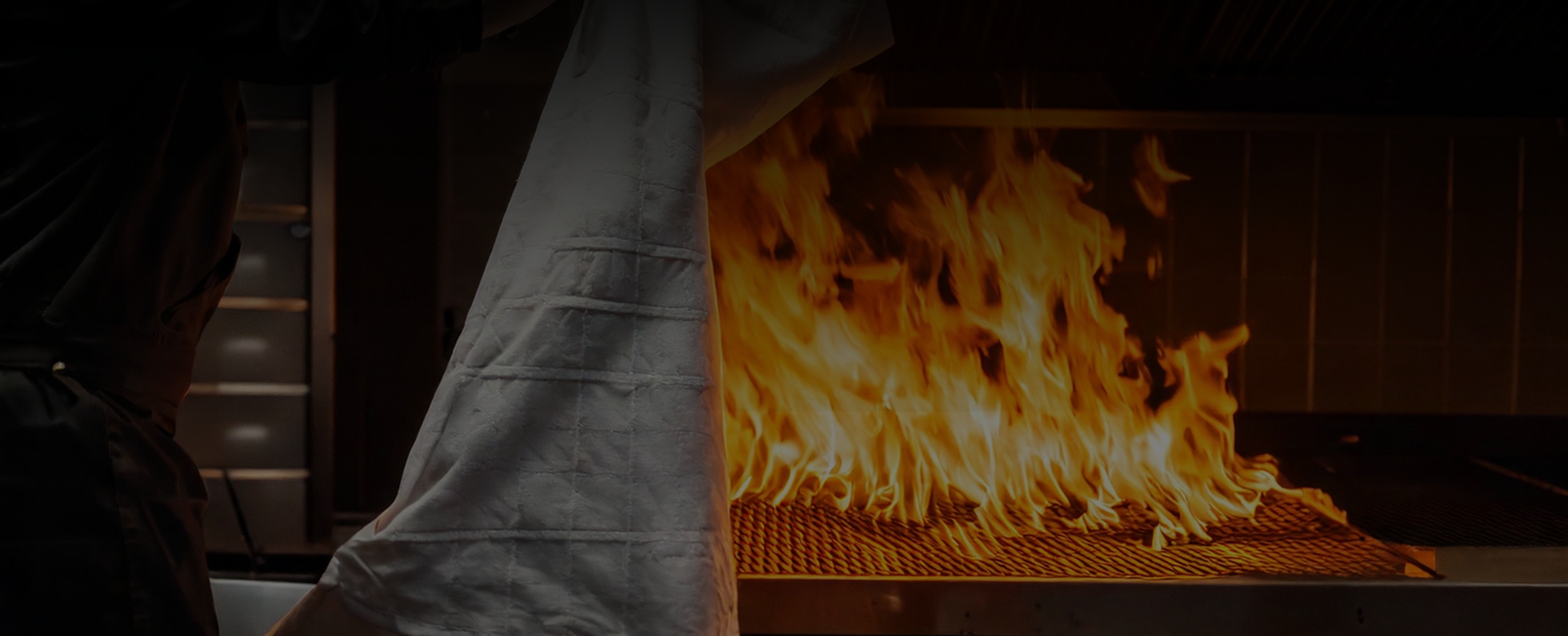 Départ de feu dans une cuisine d'un restaurant, homme tenant une couverture anti feu blanche